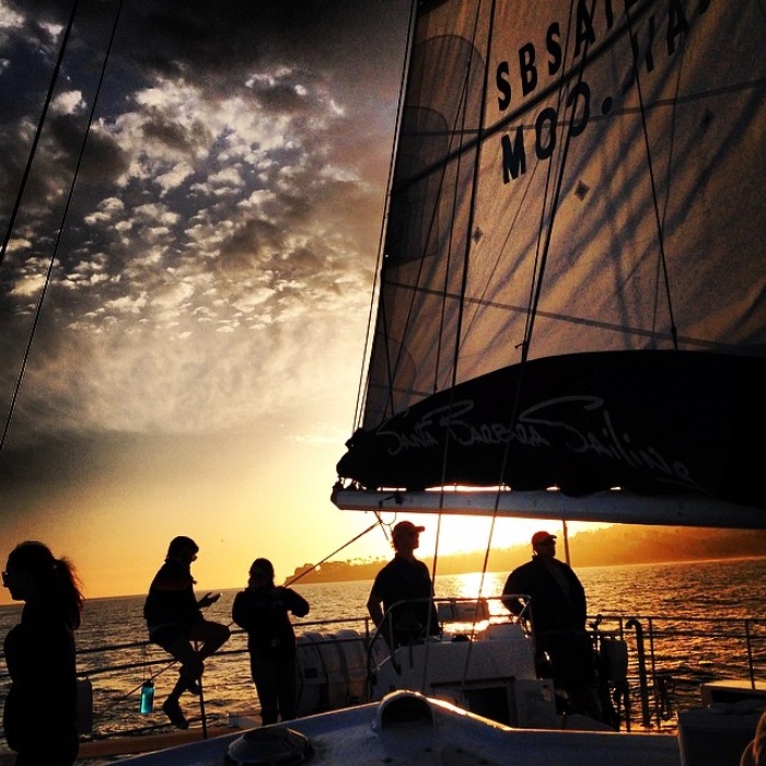 People sailing on a boat into the sun