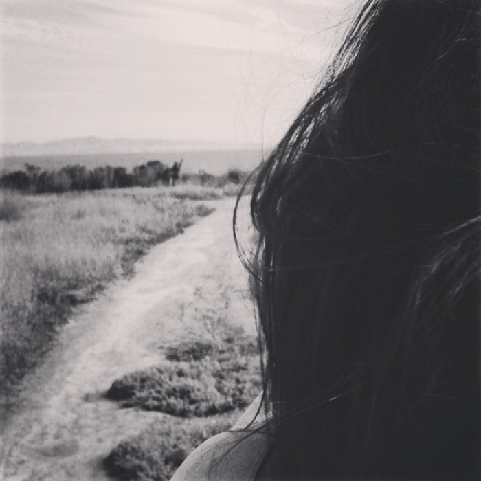 Black and white image of person standing in field
