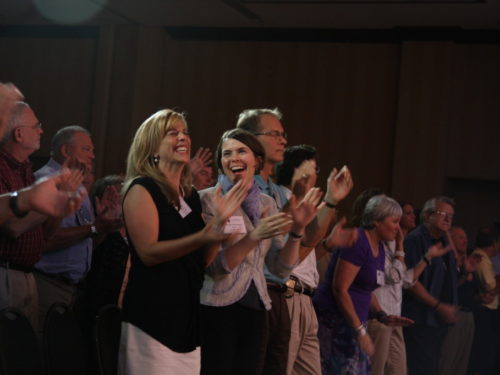 Group of people standing and clapping their hands