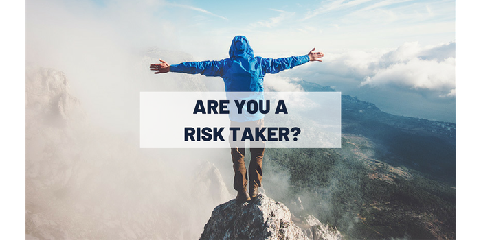 Person standing on edge of a cliff with "are you a risk taker?" on top of photo