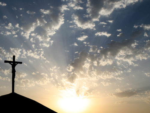 Cross on a hill with sunset in the background