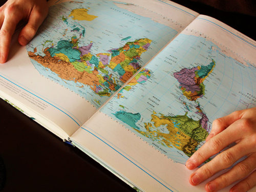Person looking at open map of the world
