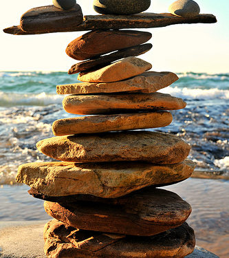 Rocks balancing on top of each other on ledge in front of the ocean